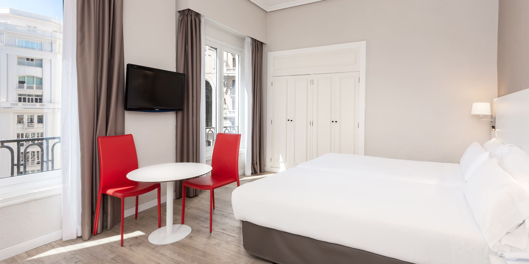 a room with a bed and a table and chairs