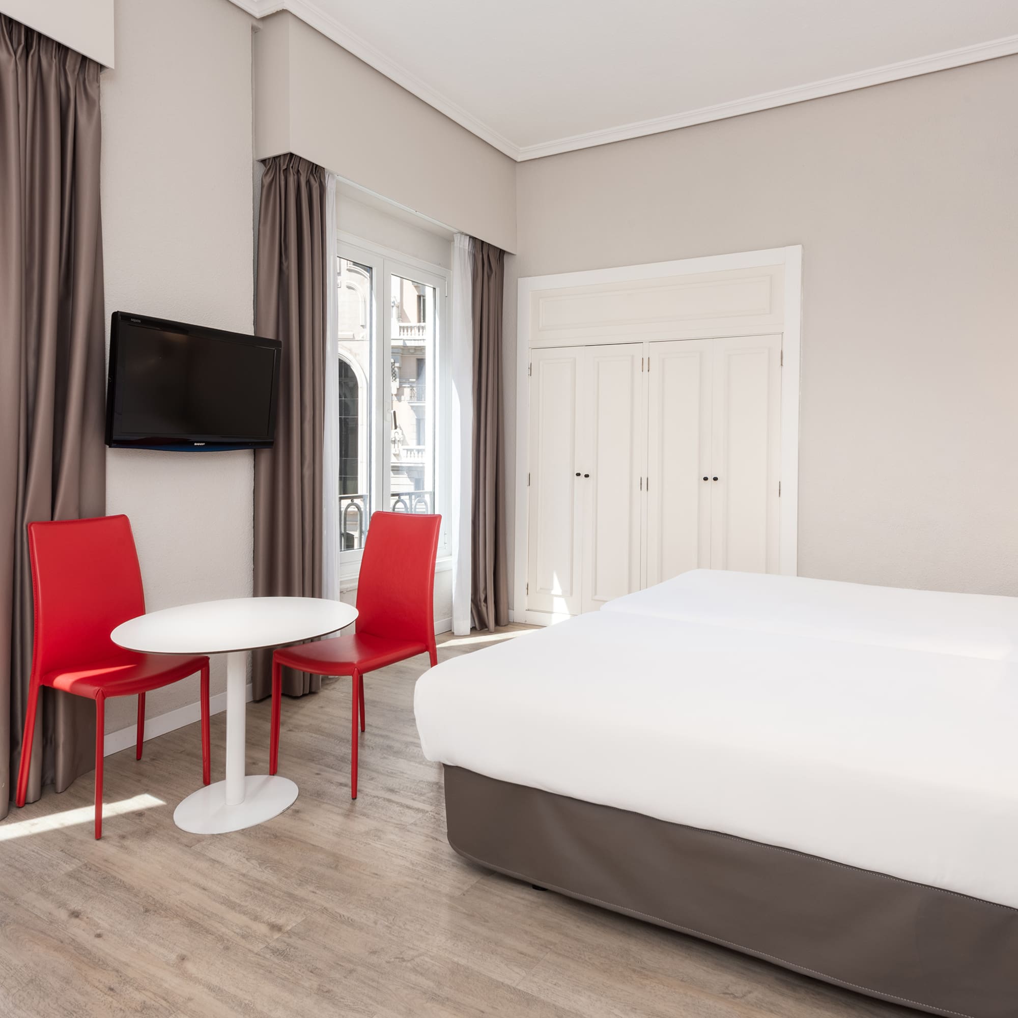 a room with a bed and a table and chairs