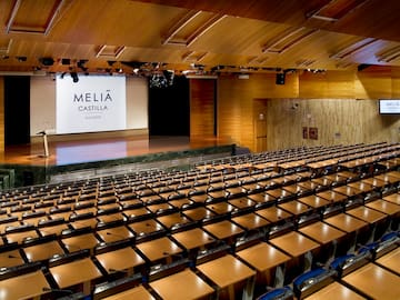 a large auditorium with chairs and a projector screen