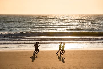 a group of people running on a beach
