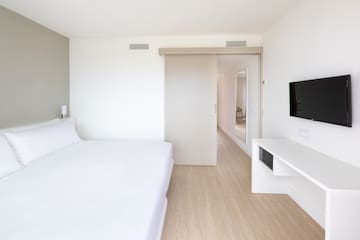 a bedroom with a bed and a tv