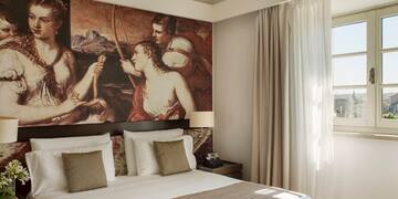 a bed with a large painting above it