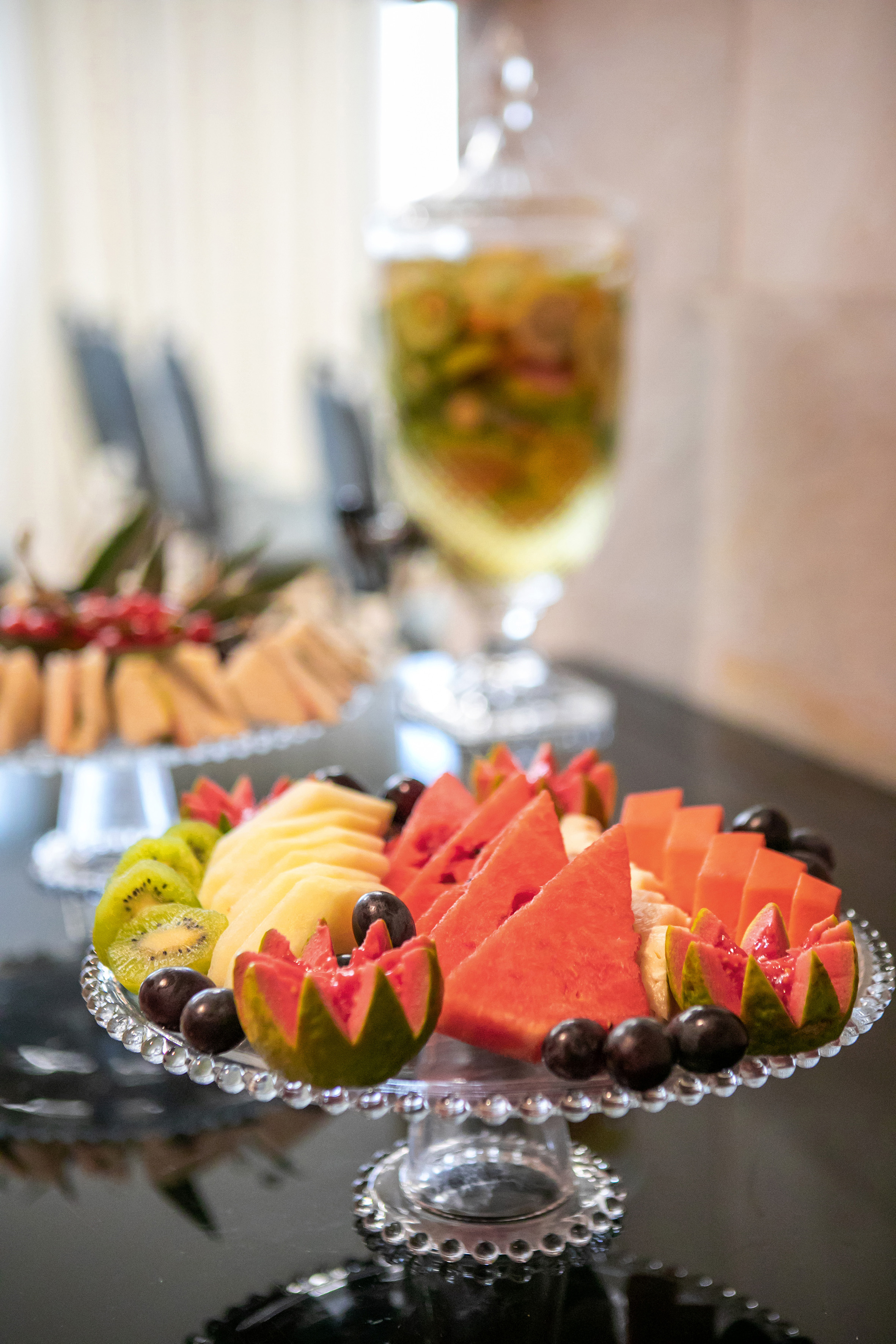 Fresh fruit platter with watermelon, kiwi, pineapple, grapes, and carved guava.