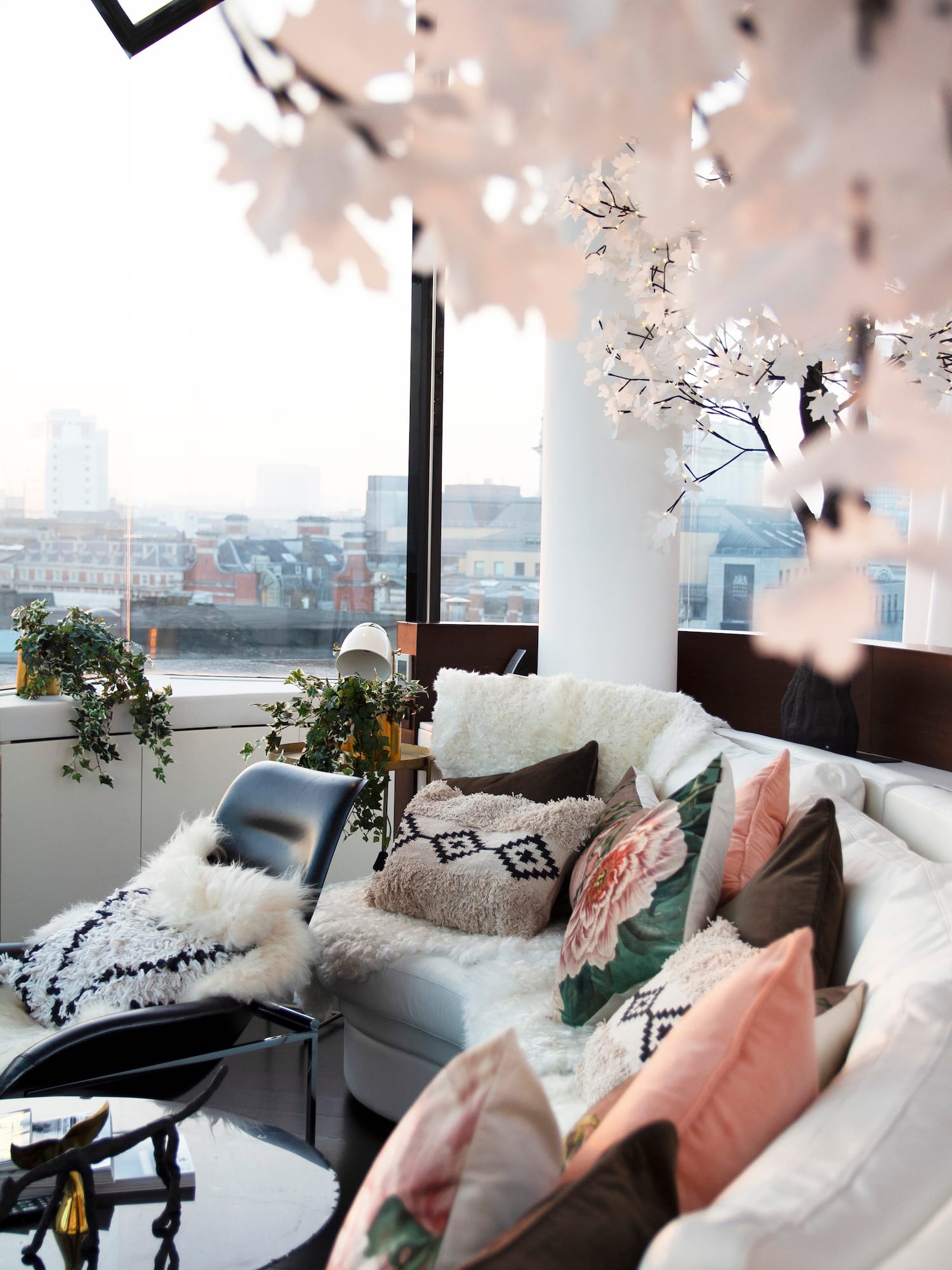 a couch with pillows and a chair in front of a window