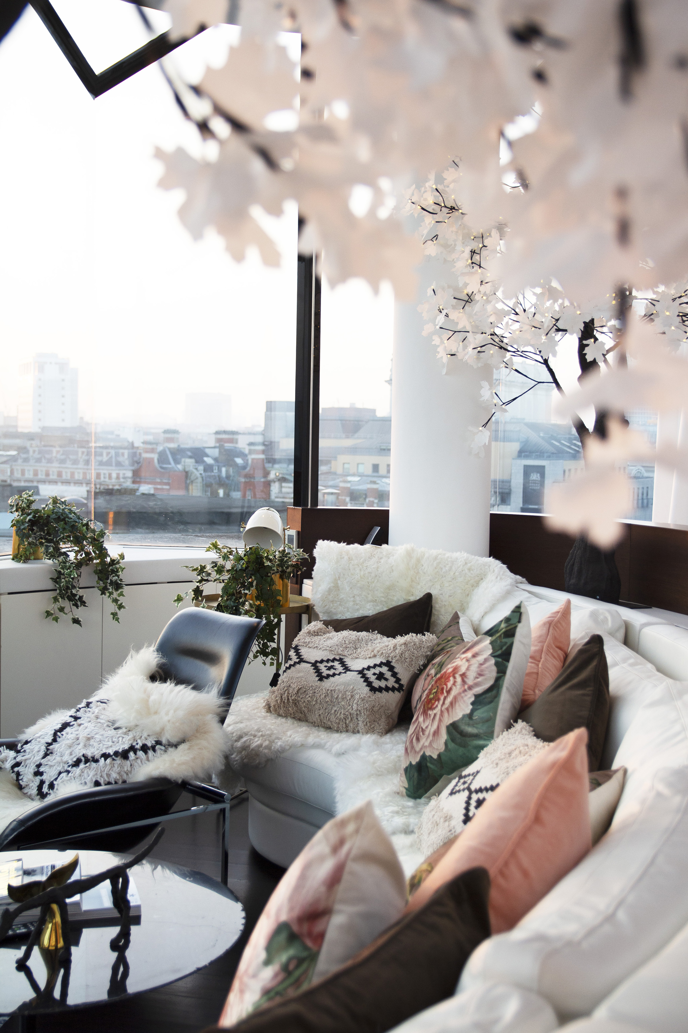 a couch with pillows and a chair in front of a window