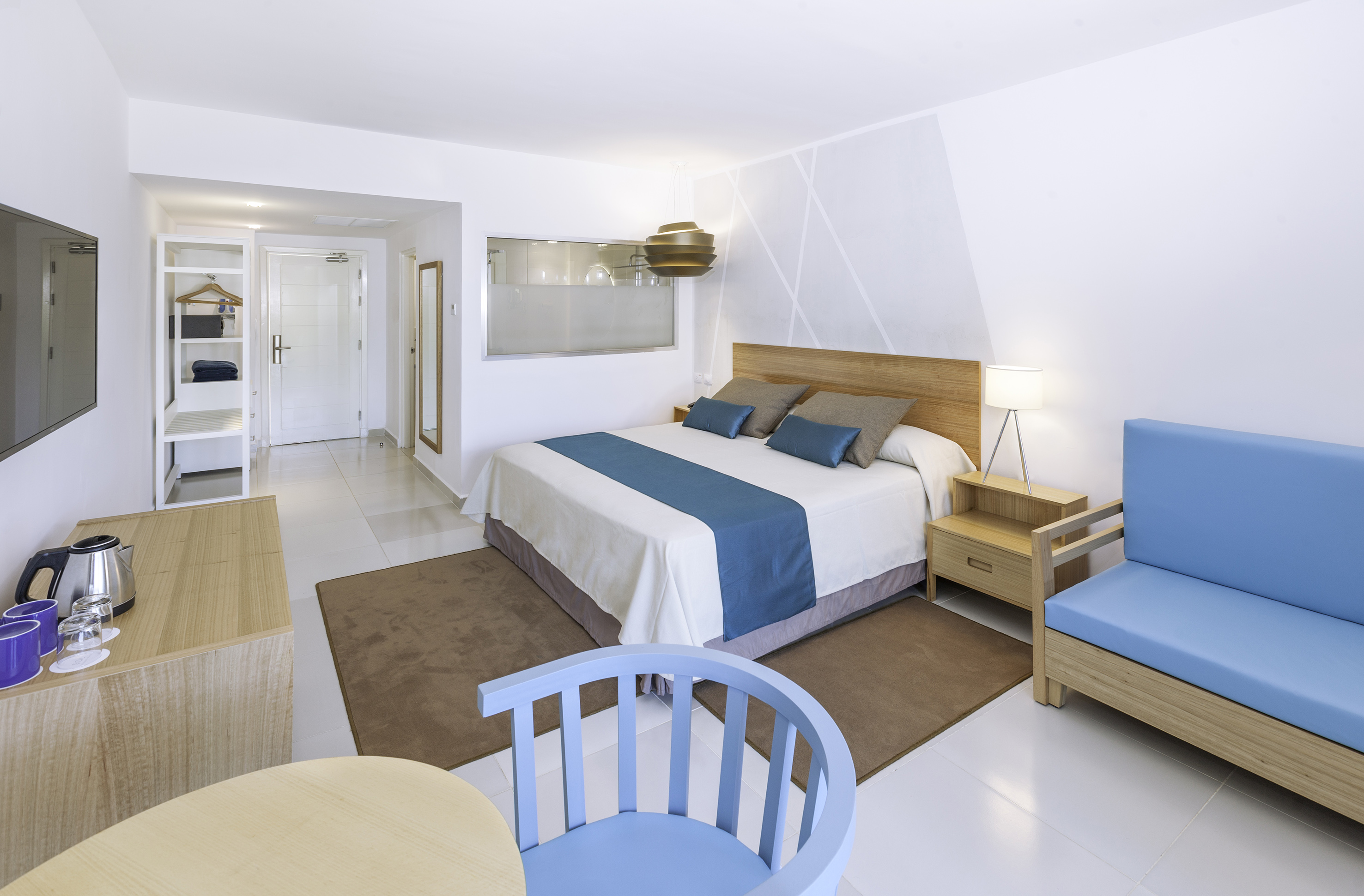 a bedroom with a bed and chairs