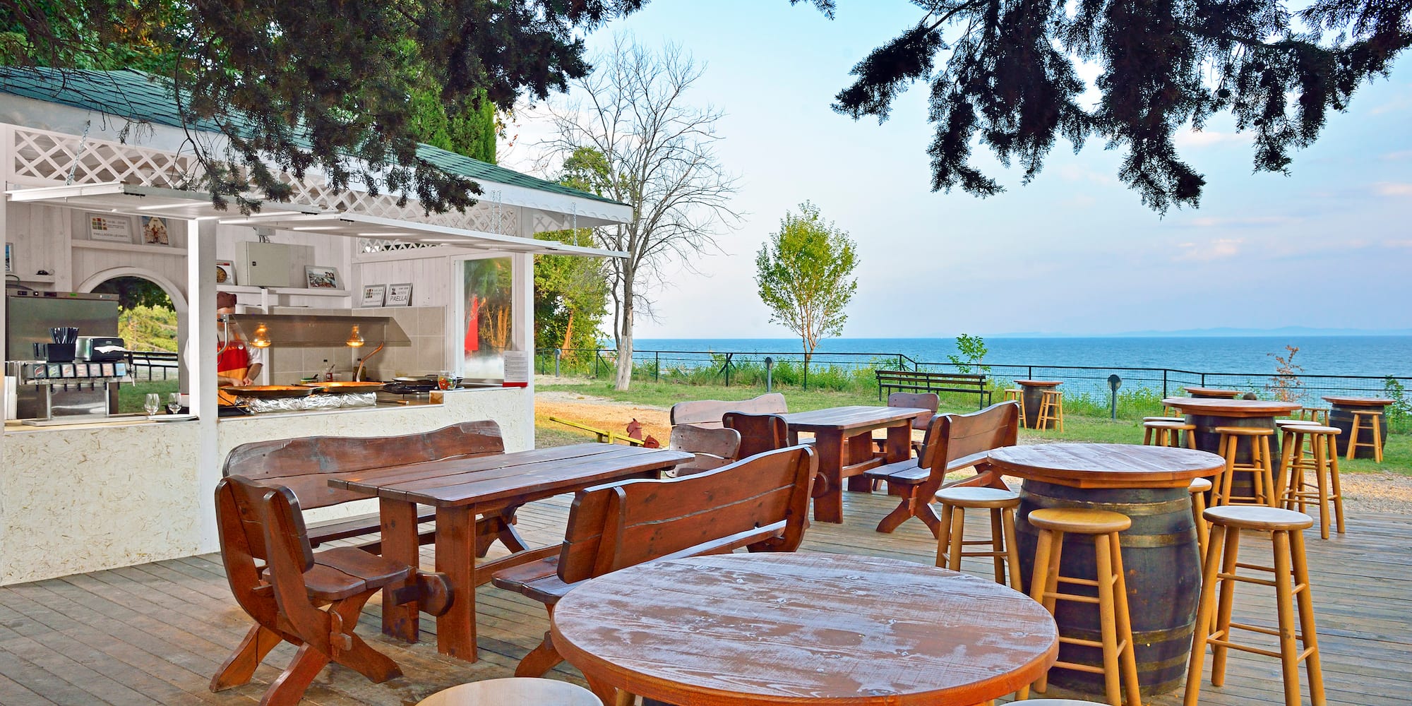 a table and chairs outside with a view of the ocean