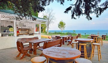 a table and chairs outside with a view of the ocean