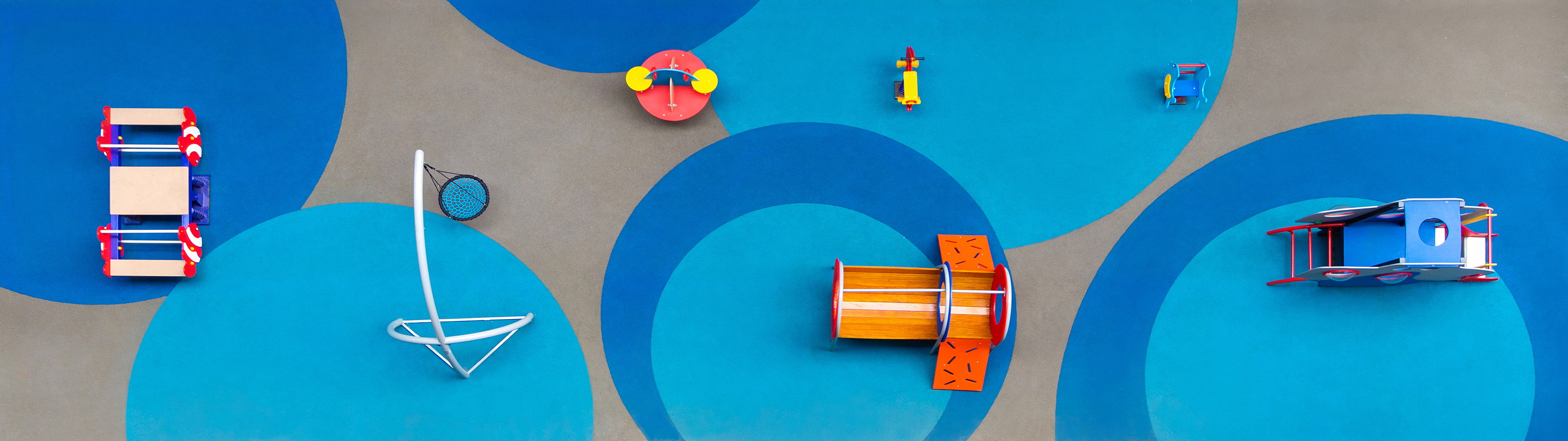Overhead view of vibrant playground with diverse blue, red, yellow play equipment.