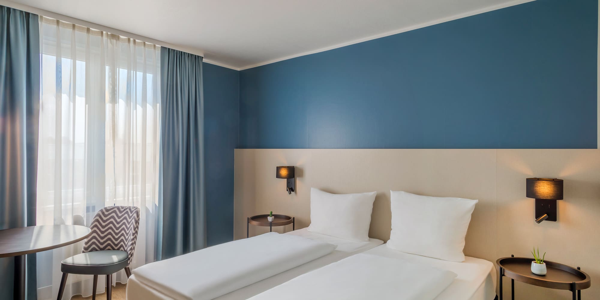 a room with two beds and a chair