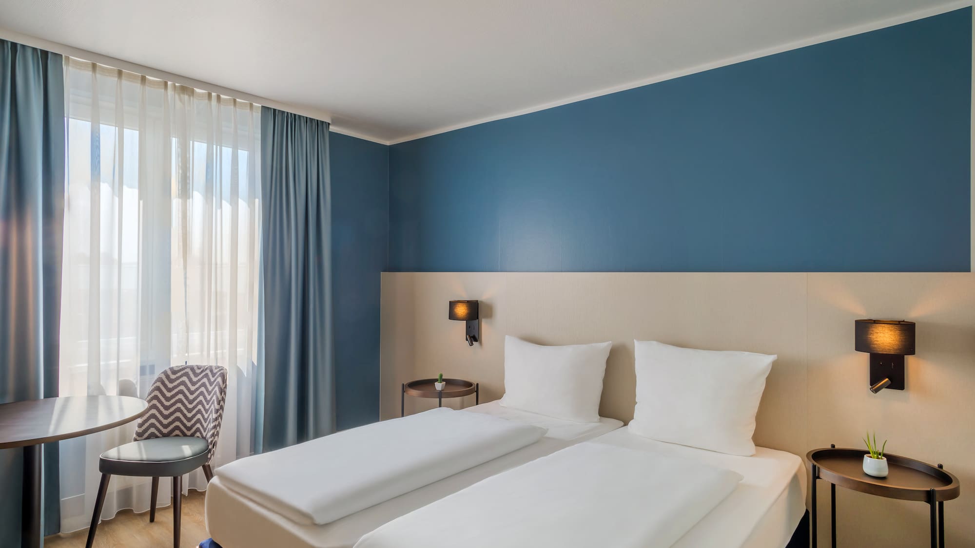 a room with two beds and a chair