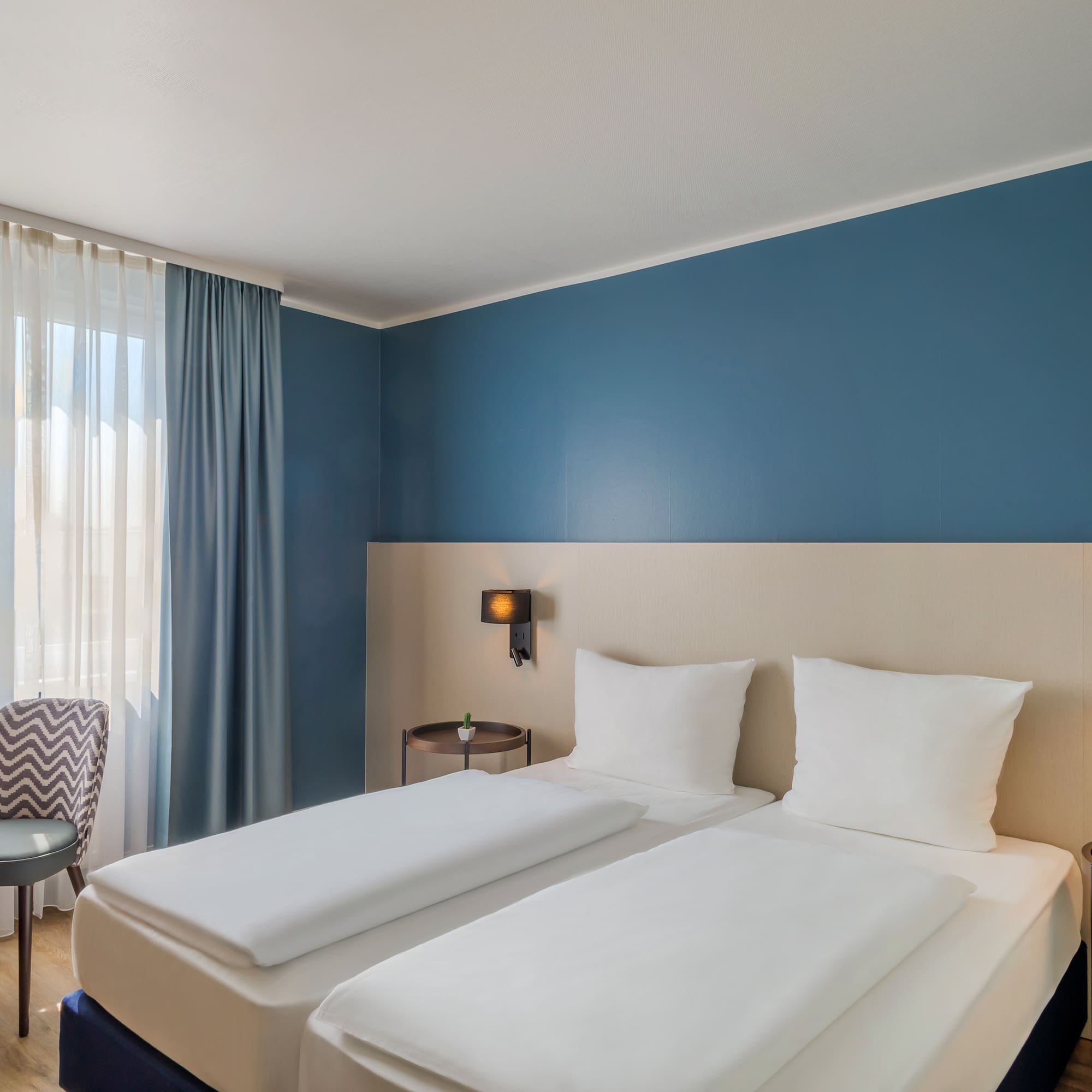 a room with two beds and a chair