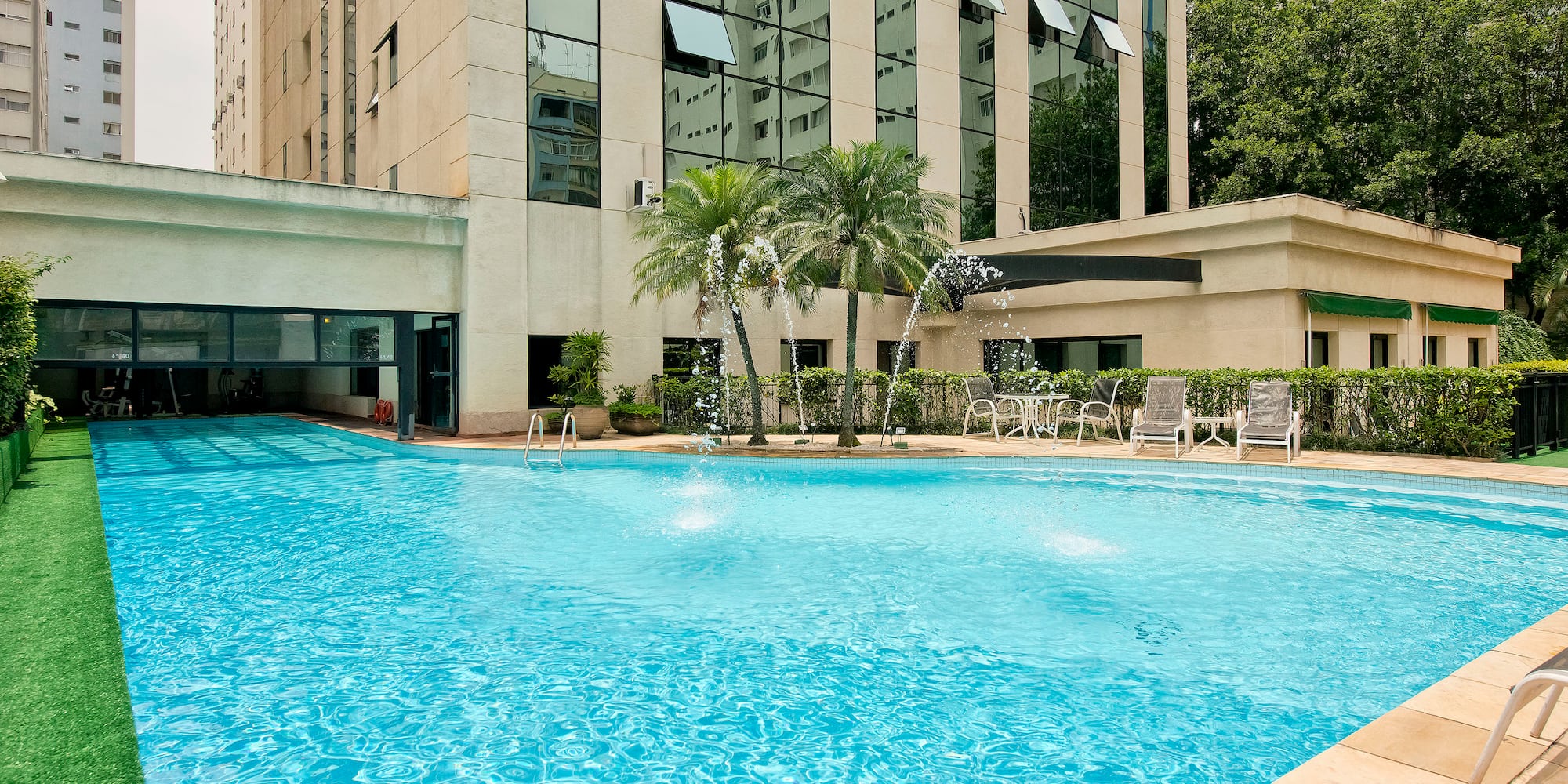 a pool with water fountain in front of a building
