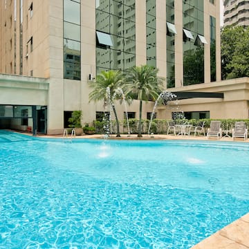 a pool with water fountain in front of a building