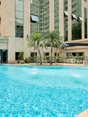 a pool with water fountain in front of a building