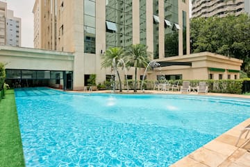 a pool with water fountain in front of a building