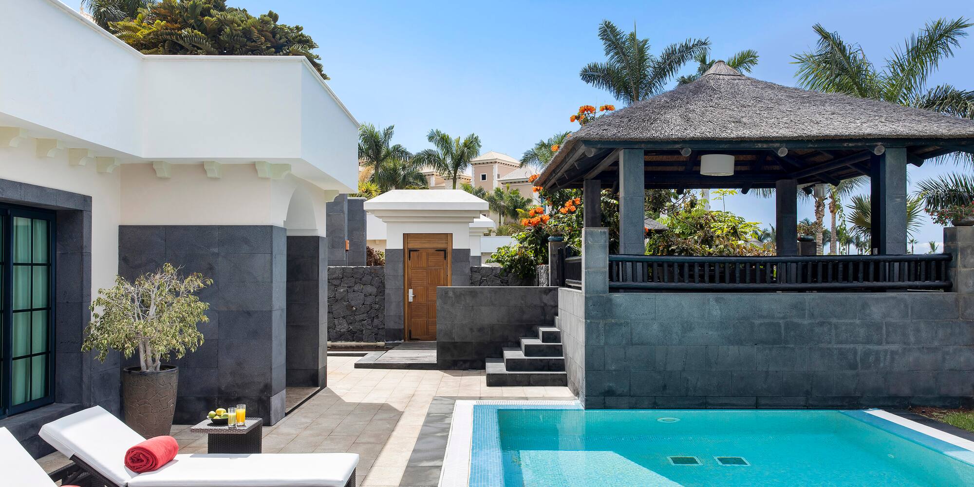 a pool with a gazebo and a wood door