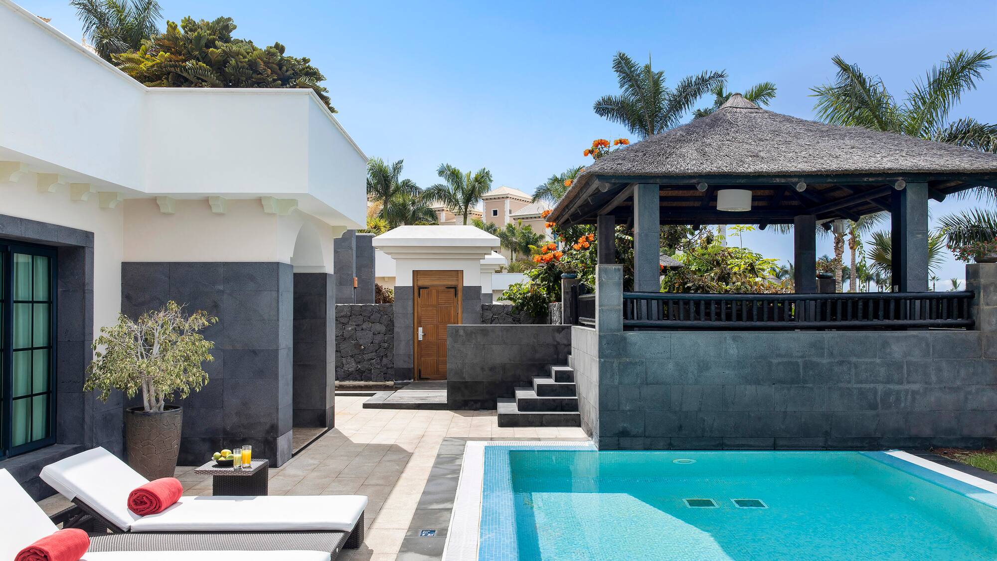a pool with a gazebo and a wood door