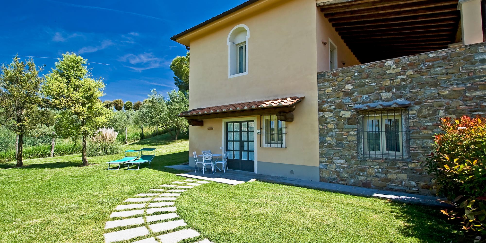 a house with a stone walkway and lawn