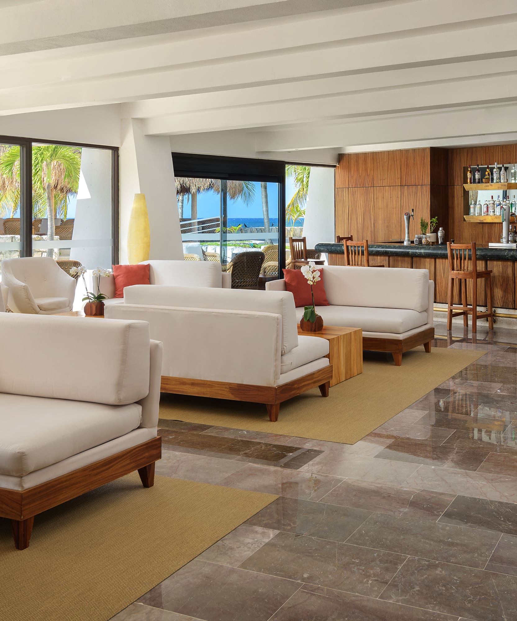 a room with white furniture and a bar