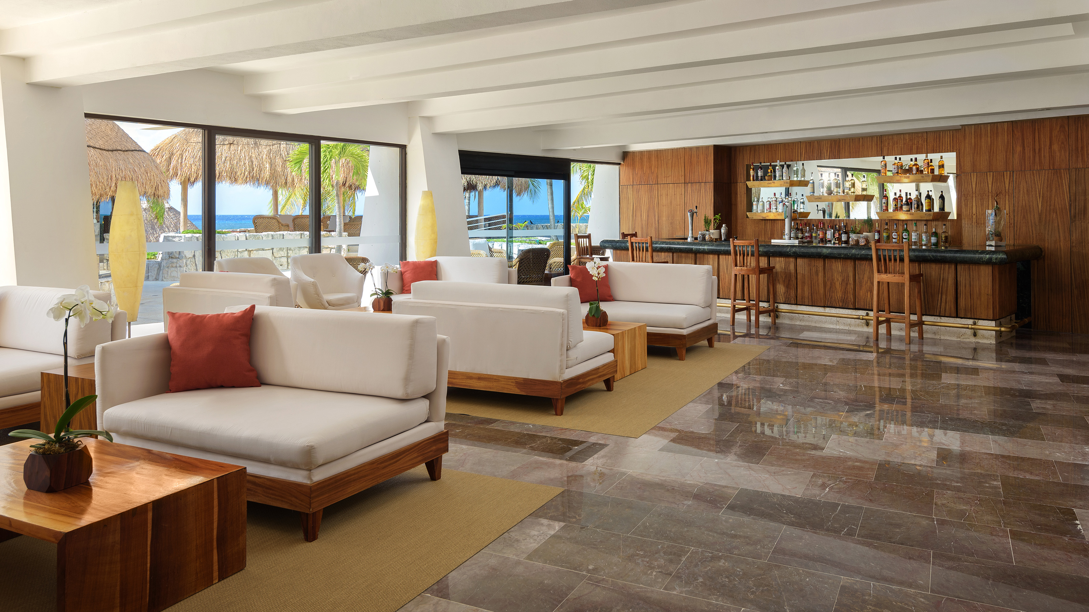 a room with white furniture and a bar