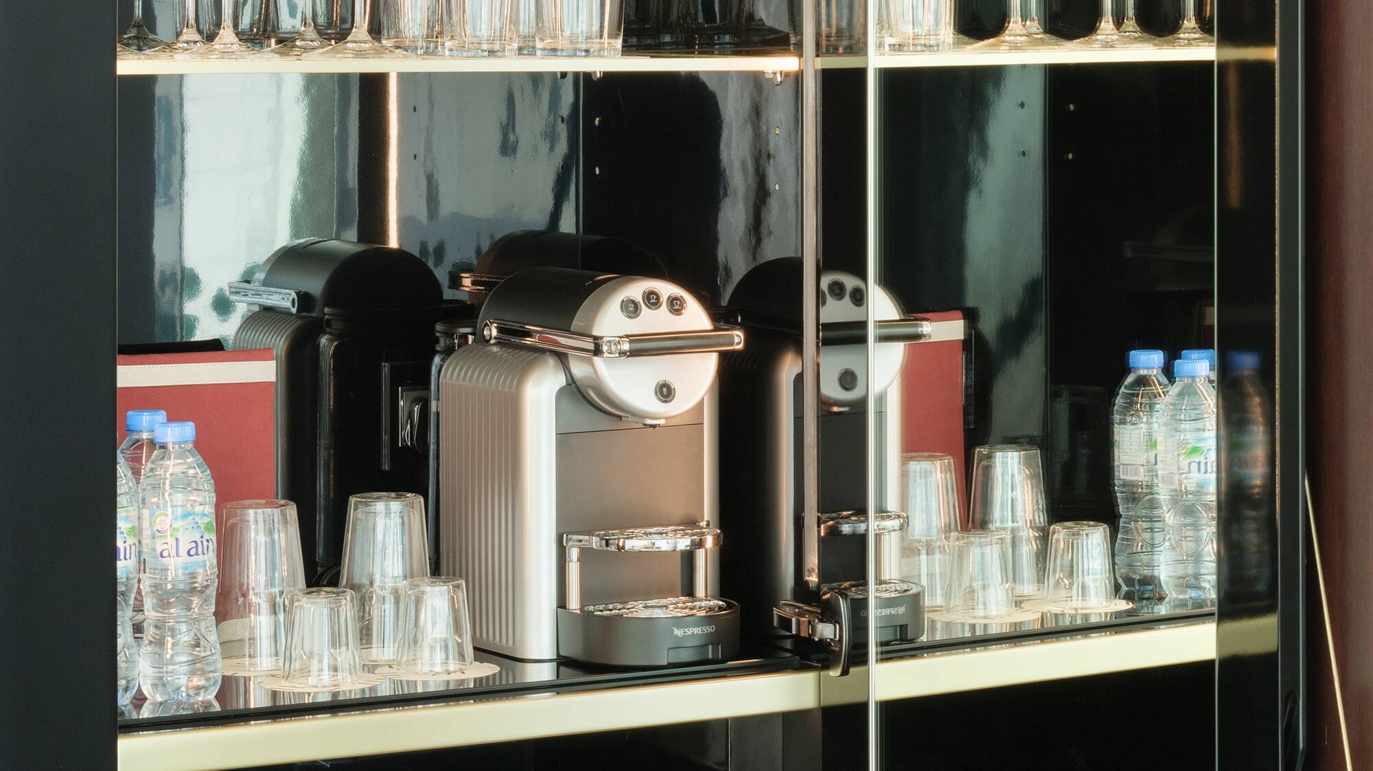 a glass cabinet with a coffee machine and glasses