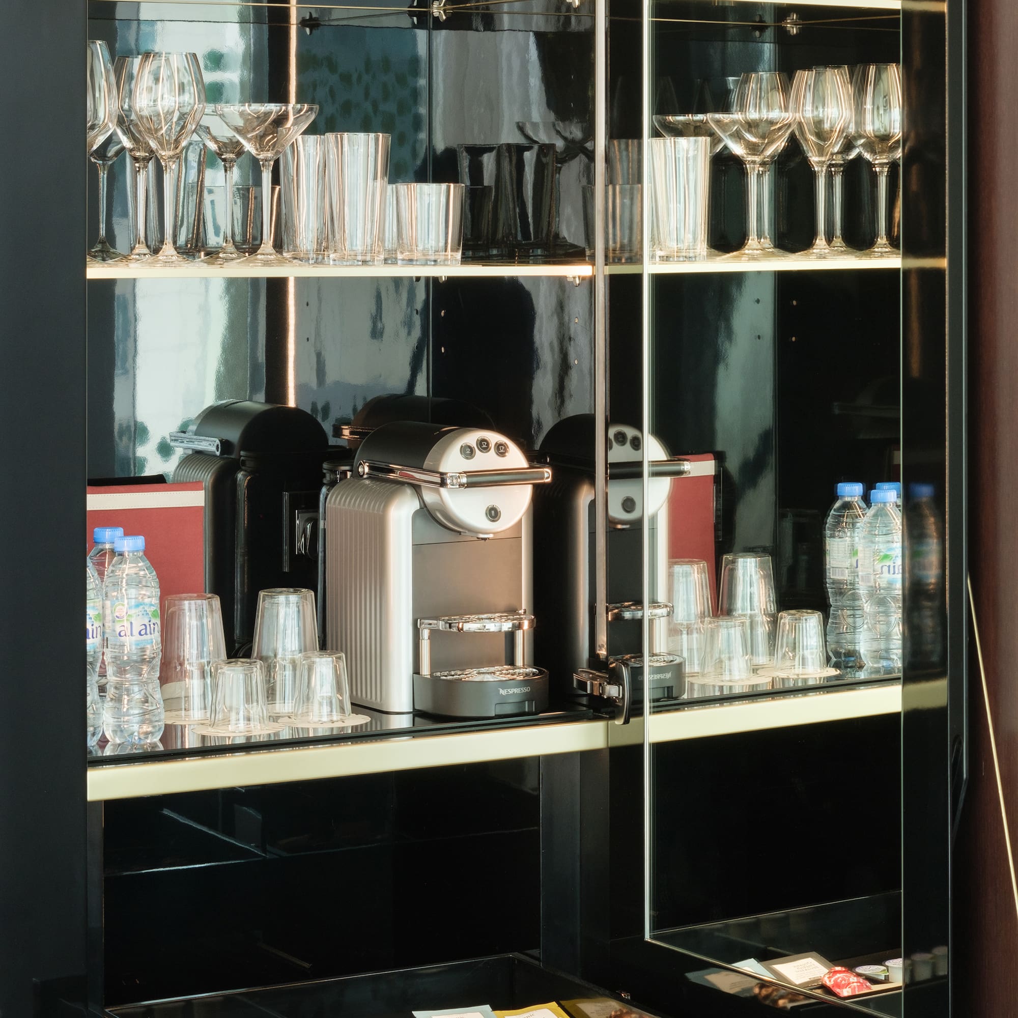 a glass cabinet with a coffee machine and glasses