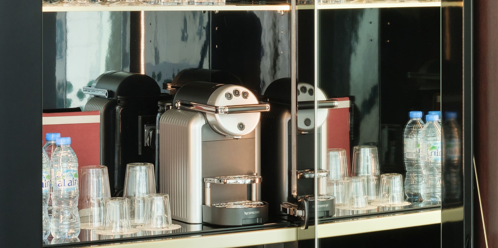 a glass cabinet with a coffee machine and glasses