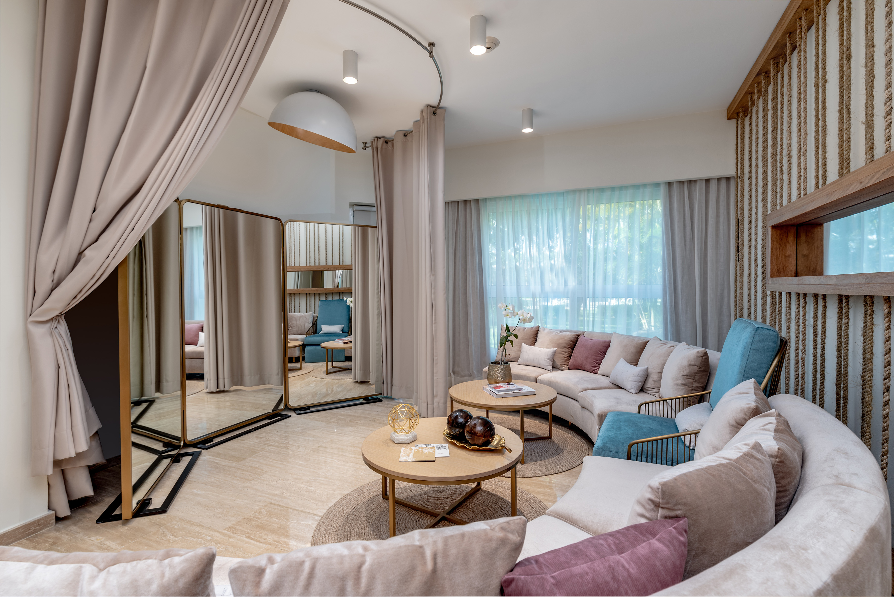 Modern lounge interior with curved sofa, accent chairs, and changing room.
