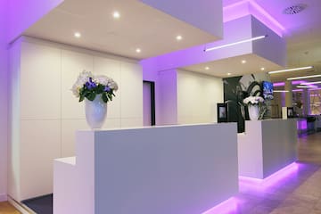 a reception desk in a room with purple lighting