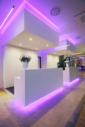 a reception desk in a room with purple lighting