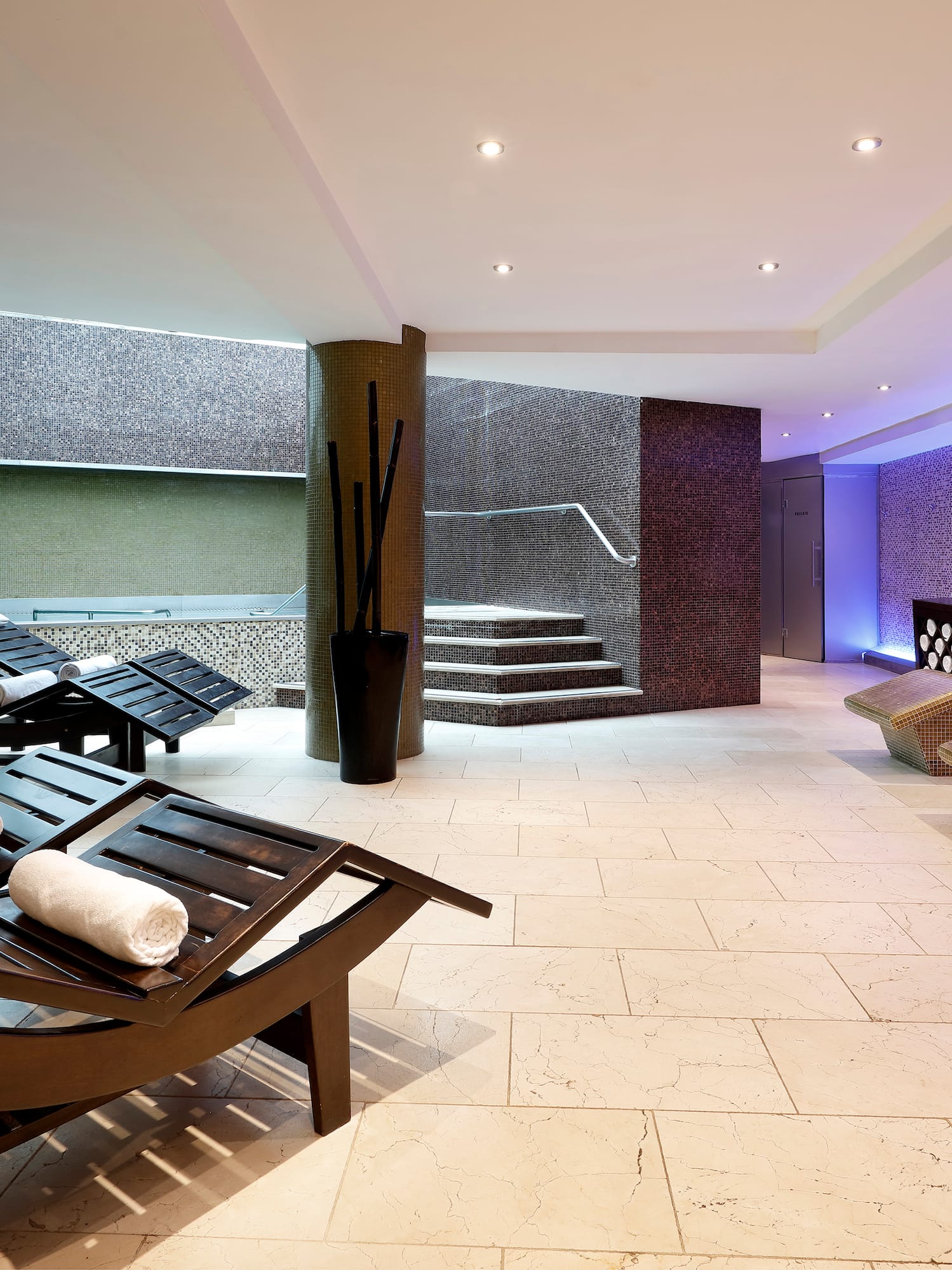 a room with chairs and a pool