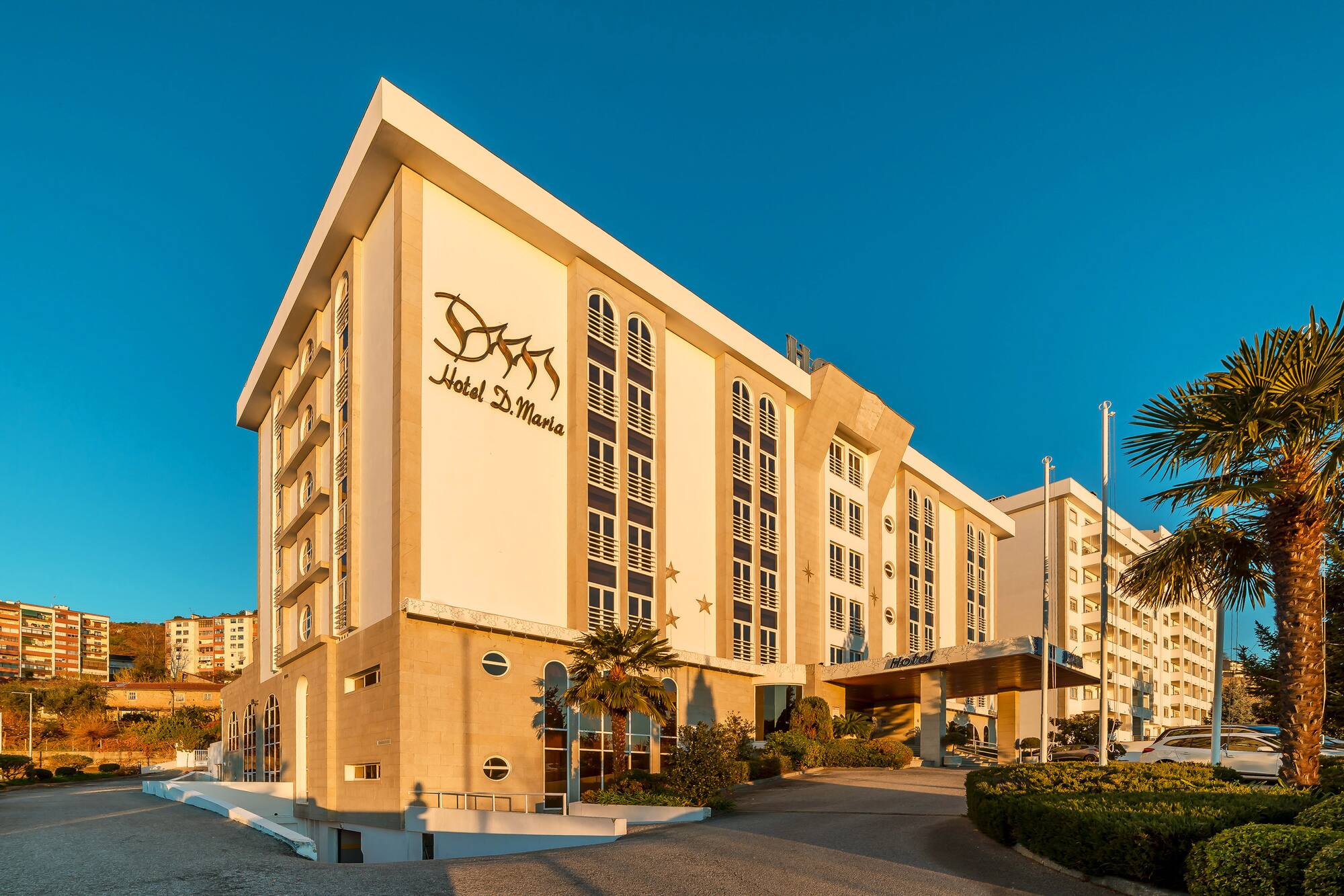 Hotel D. Maria building facade, modern design, sunny, blue sky, palm trees.