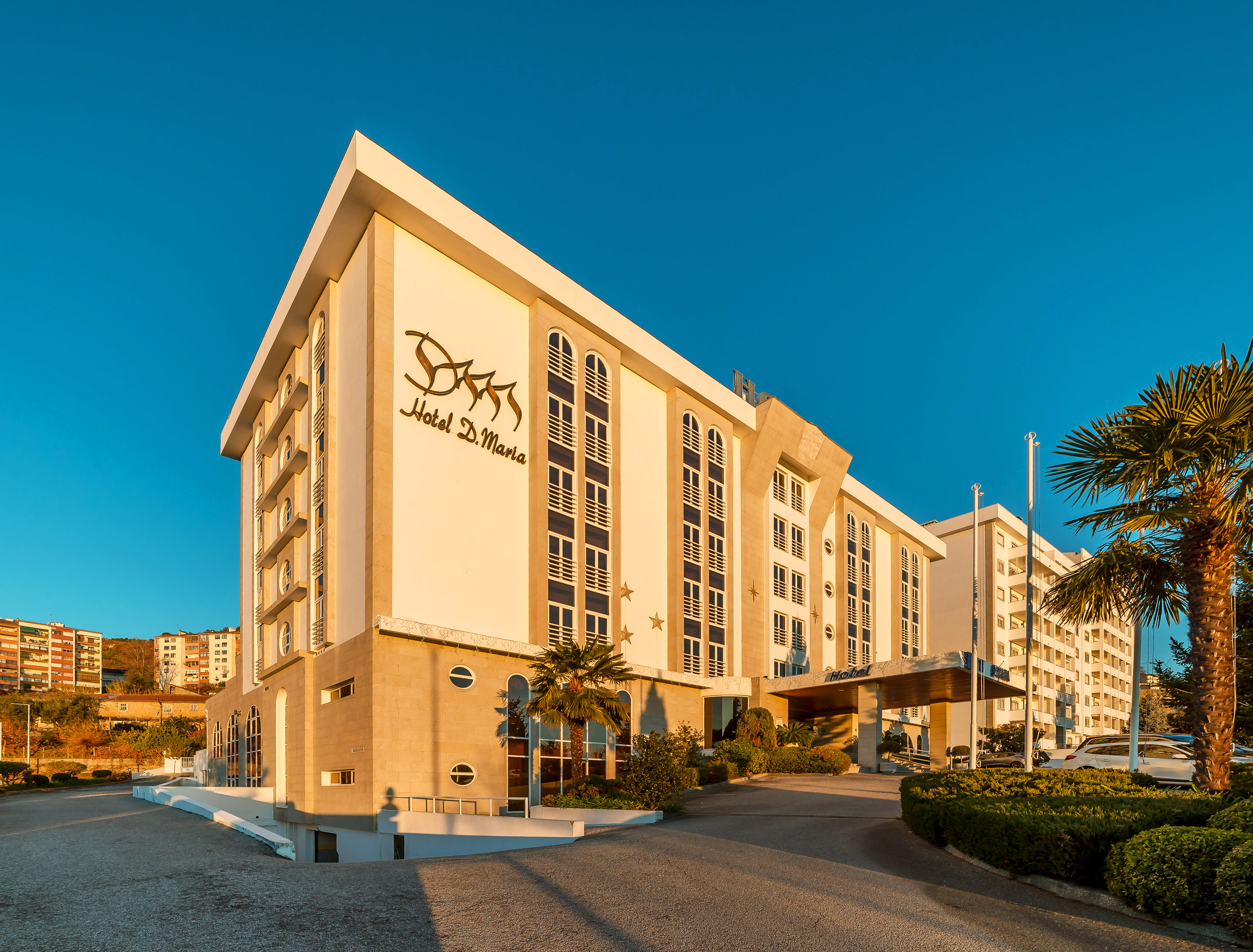 Hotel D. Maria building facade, modern design, sunny, blue sky, palm trees.