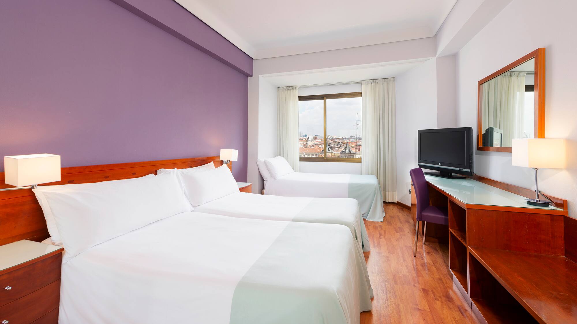 a room with two beds and a purple wall