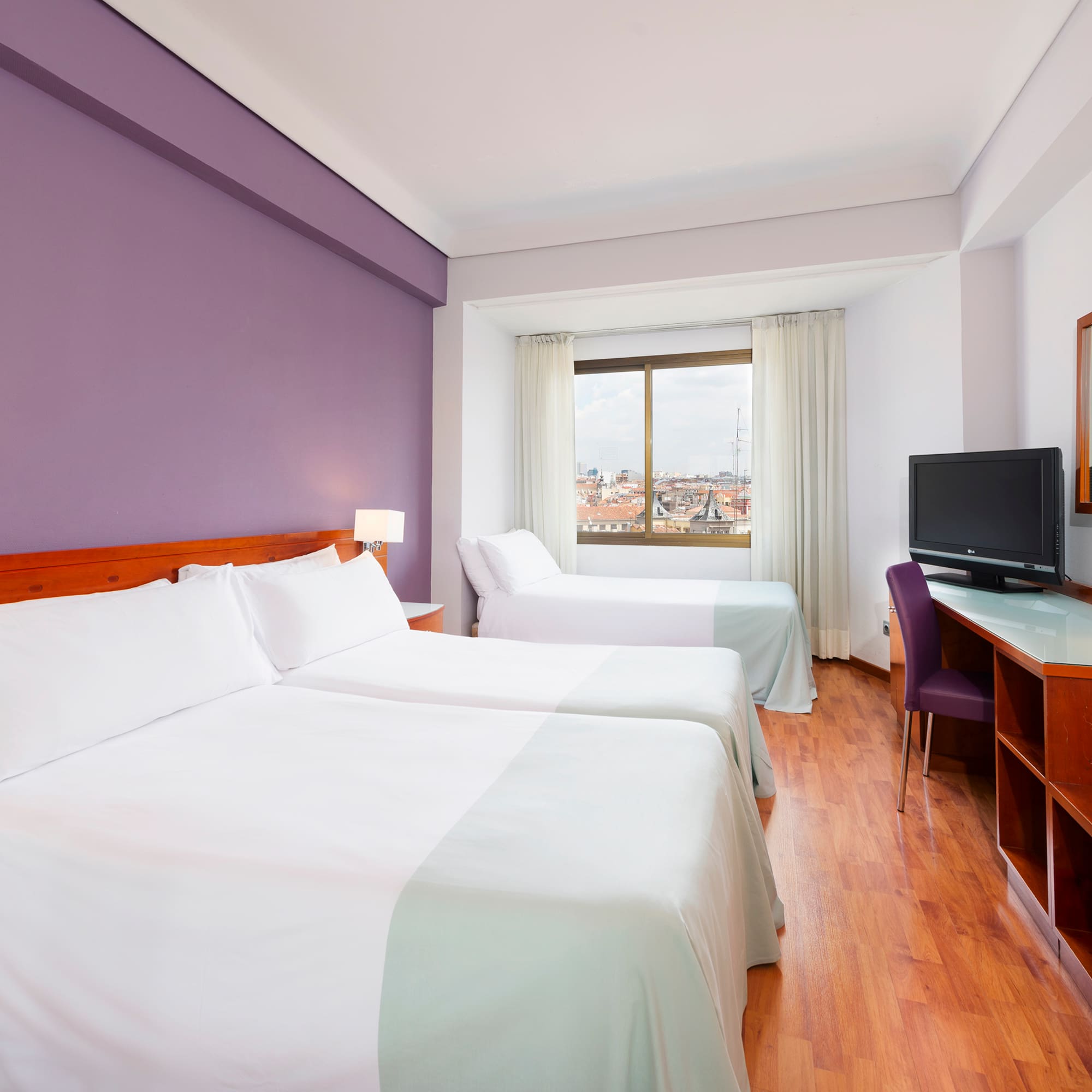 a room with two beds and a purple wall