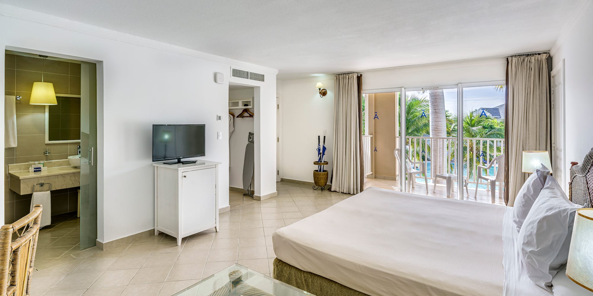 a bedroom with a television and a balcony