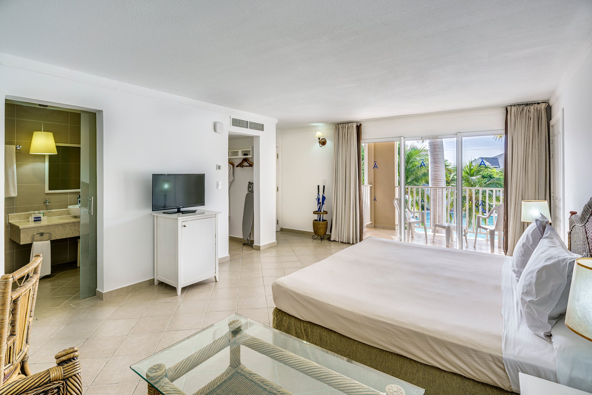 a bedroom with a television and a balcony