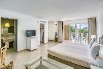 a bedroom with a television and a balcony
