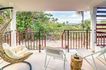 a deck with chairs and a view of the ocean