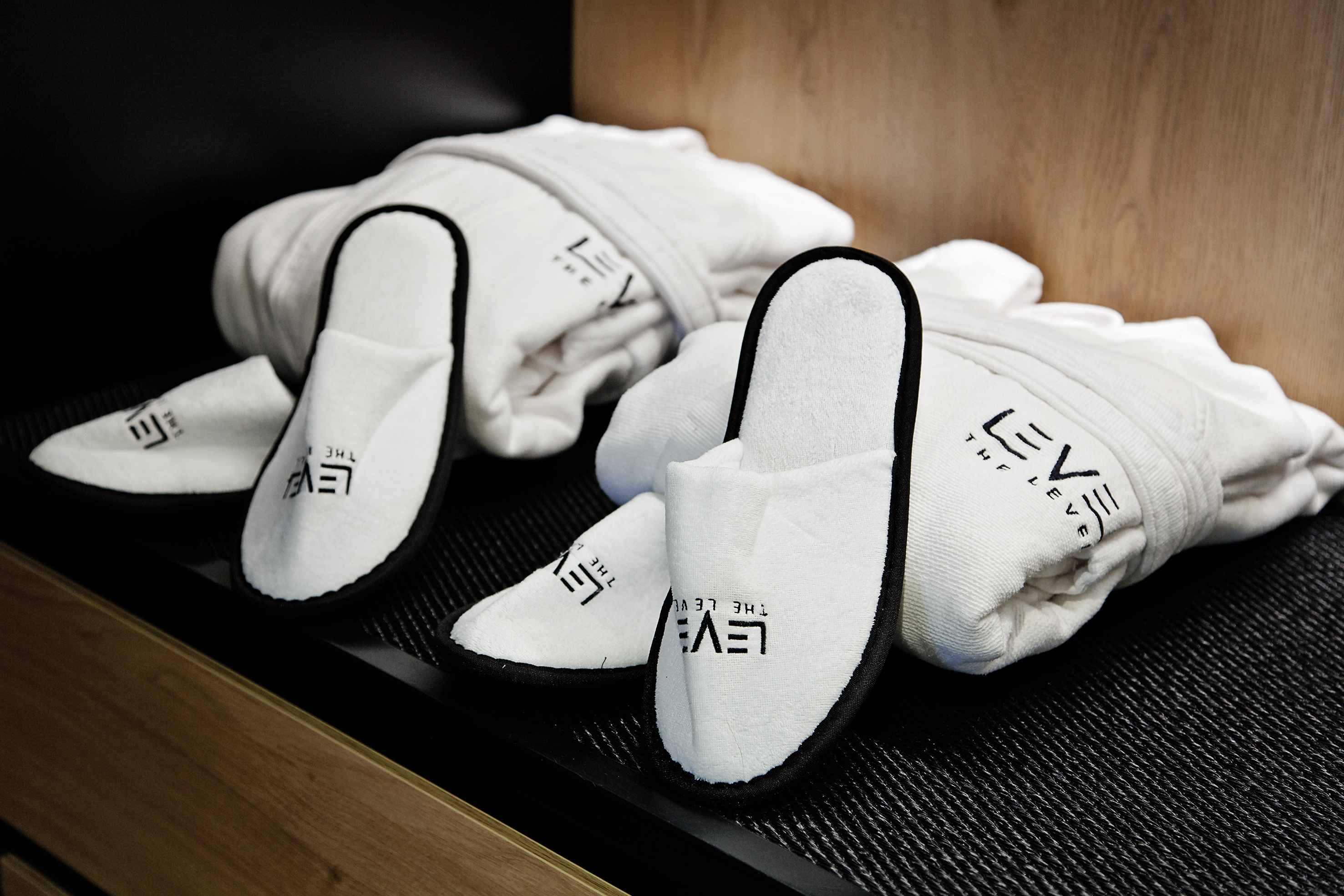 Luxury hotel white slippers and bathrobes with 'THE LEVEL' logo.