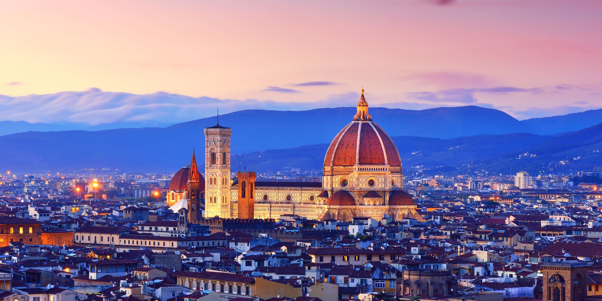 a city with a dome and a mountain in the background