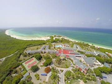 a aerial view of a resort with a beach and trees