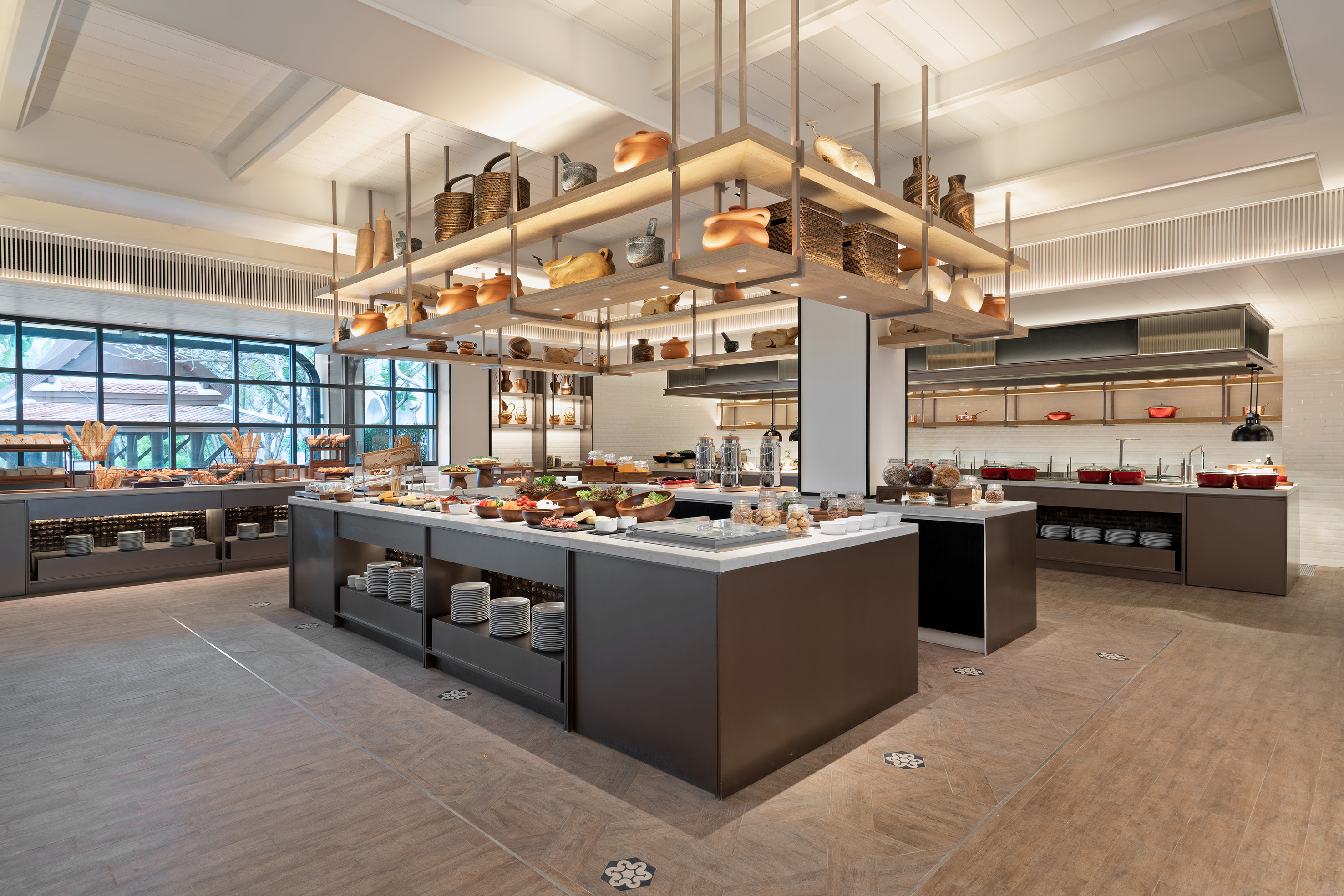 Modern hotel buffet with diverse food stations and elegant decor.