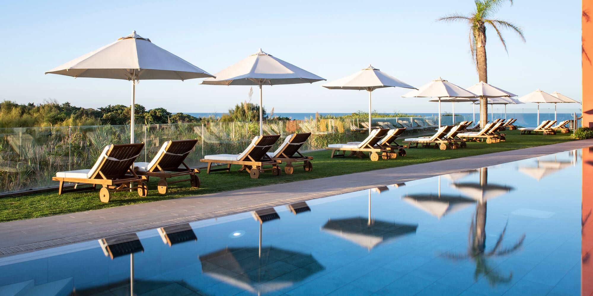 a pool with chairs and umbrellas