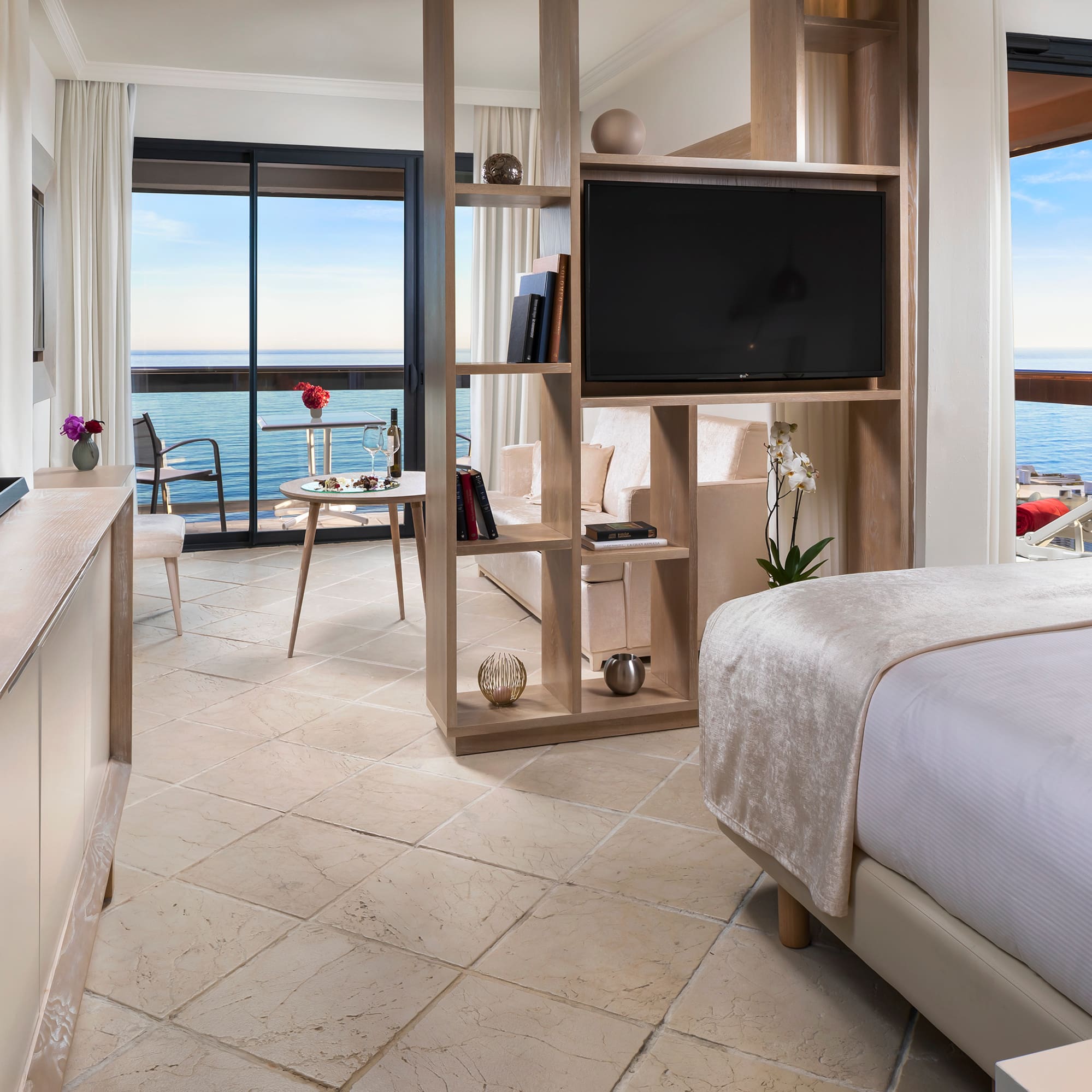 a room with a television and a view of the ocean