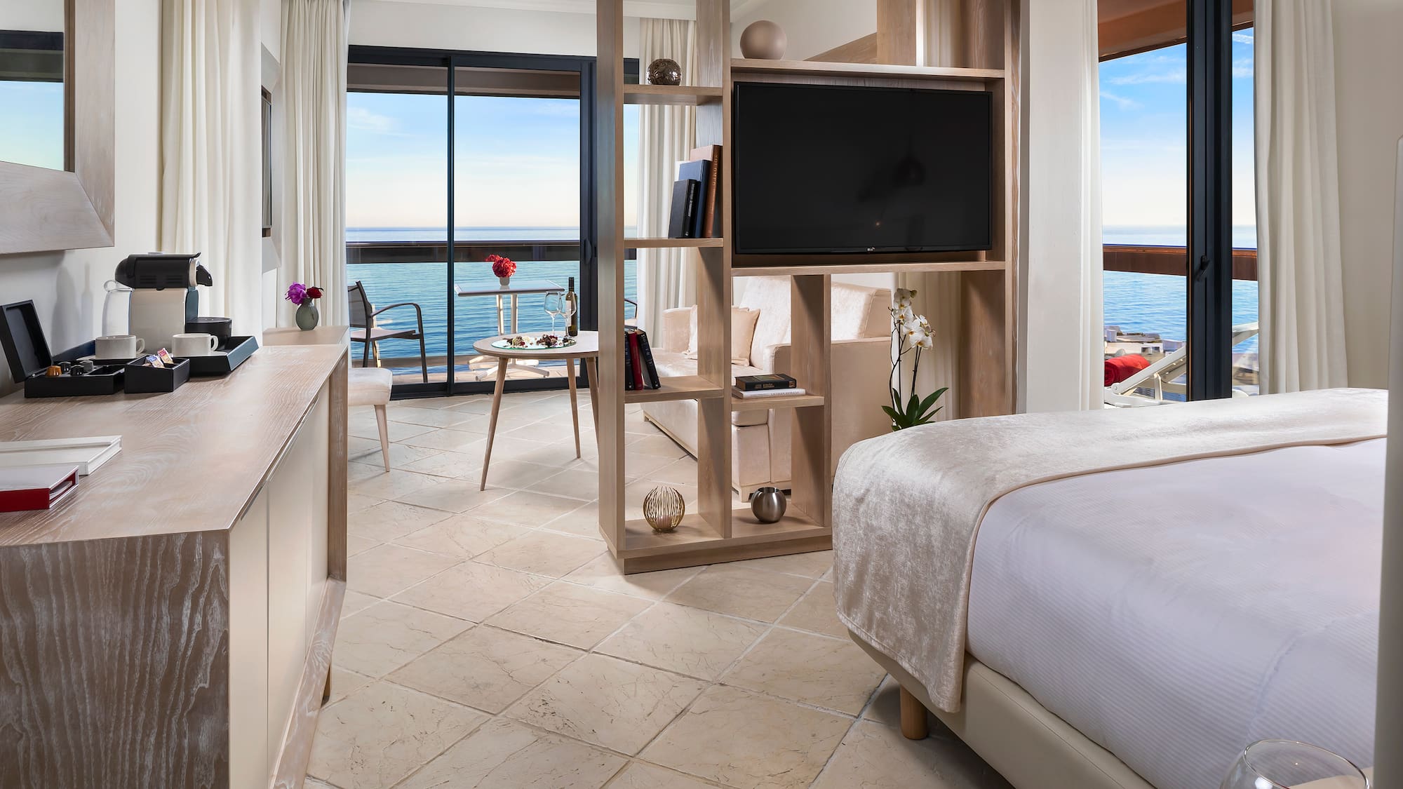 a room with a television and a view of the ocean