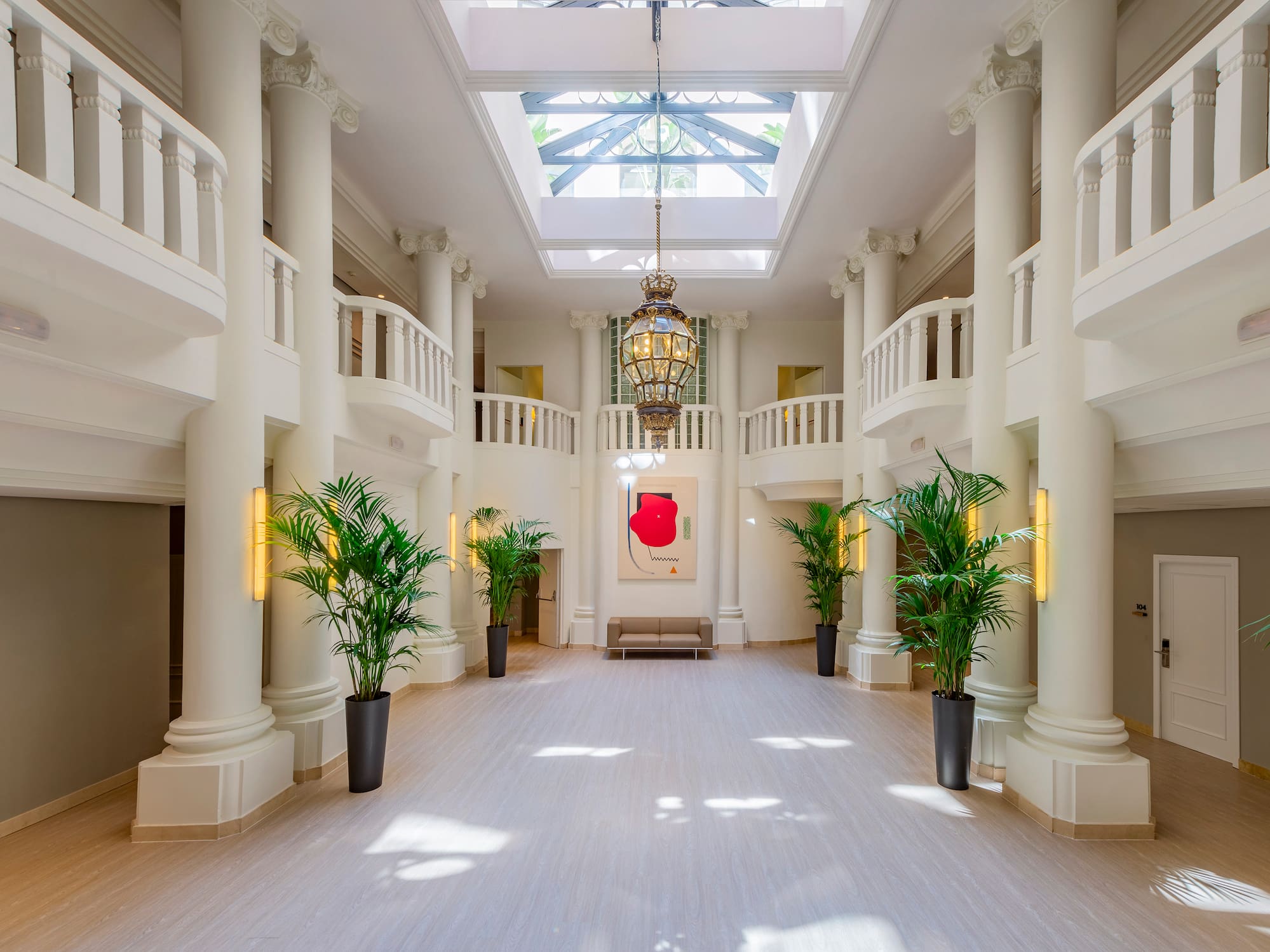 a large white room with columns and plants