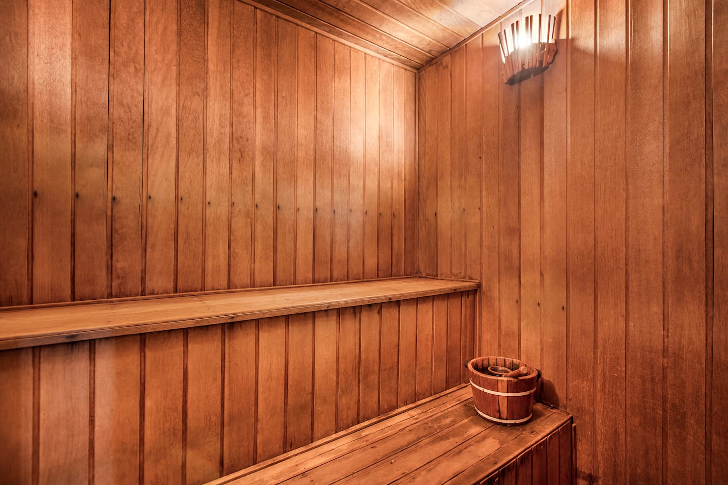 a wooden sauna with a bucket and bucket on a bench