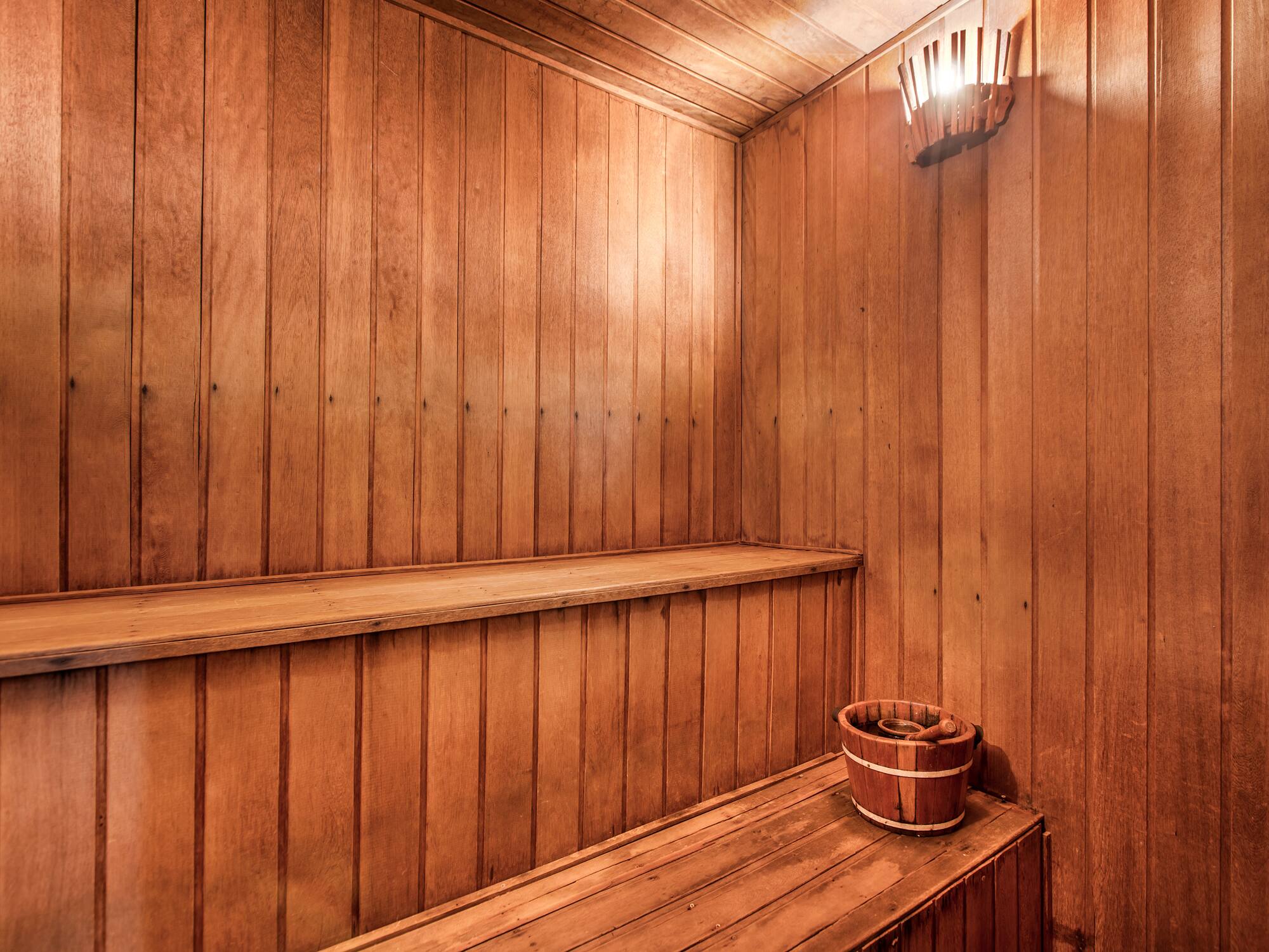 a wooden sauna with a bucket and bucket on a bench